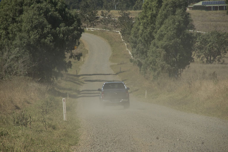 Car driving on dusty road